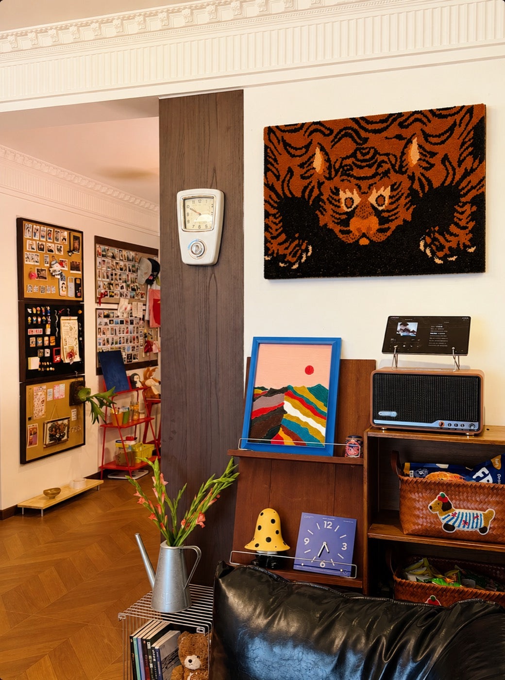 A hand-tufted wool tiger portrait in rust and black hung above a record player in a collector's apartment