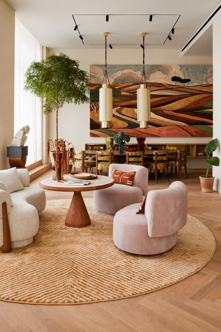 A wide hand-tufted wool landscape of rolling fields in rust, ochre and olive hung above a dining table