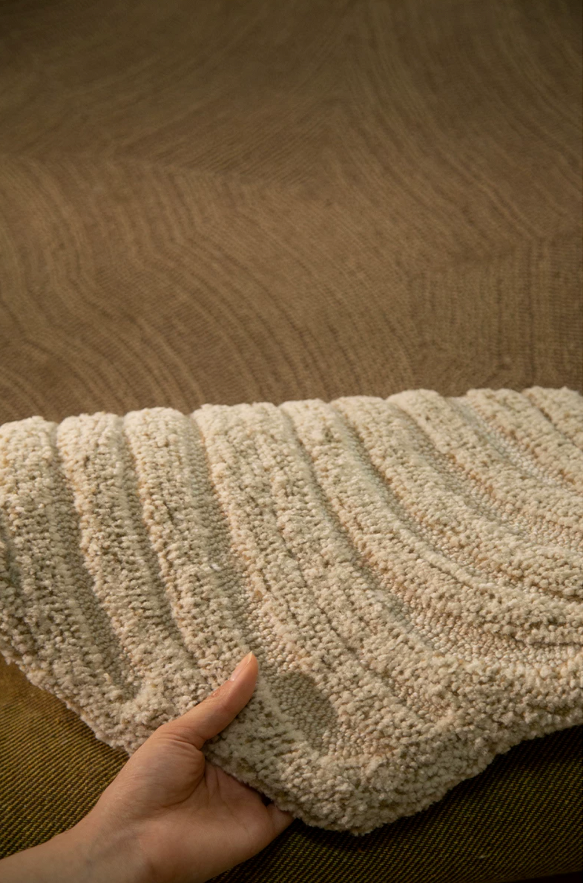 Hewn Earth Studio Camellia rug with a clay and bloom floral design, showcasing the back side of the woven fabric.