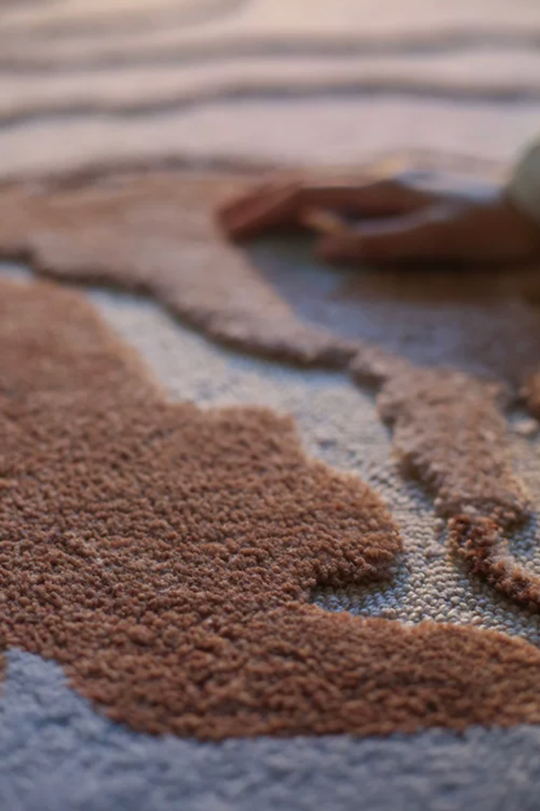 Close-up of Hewn Earth Studio Delta terracotta rug showcasing textured woven pattern and rich earthy tones.