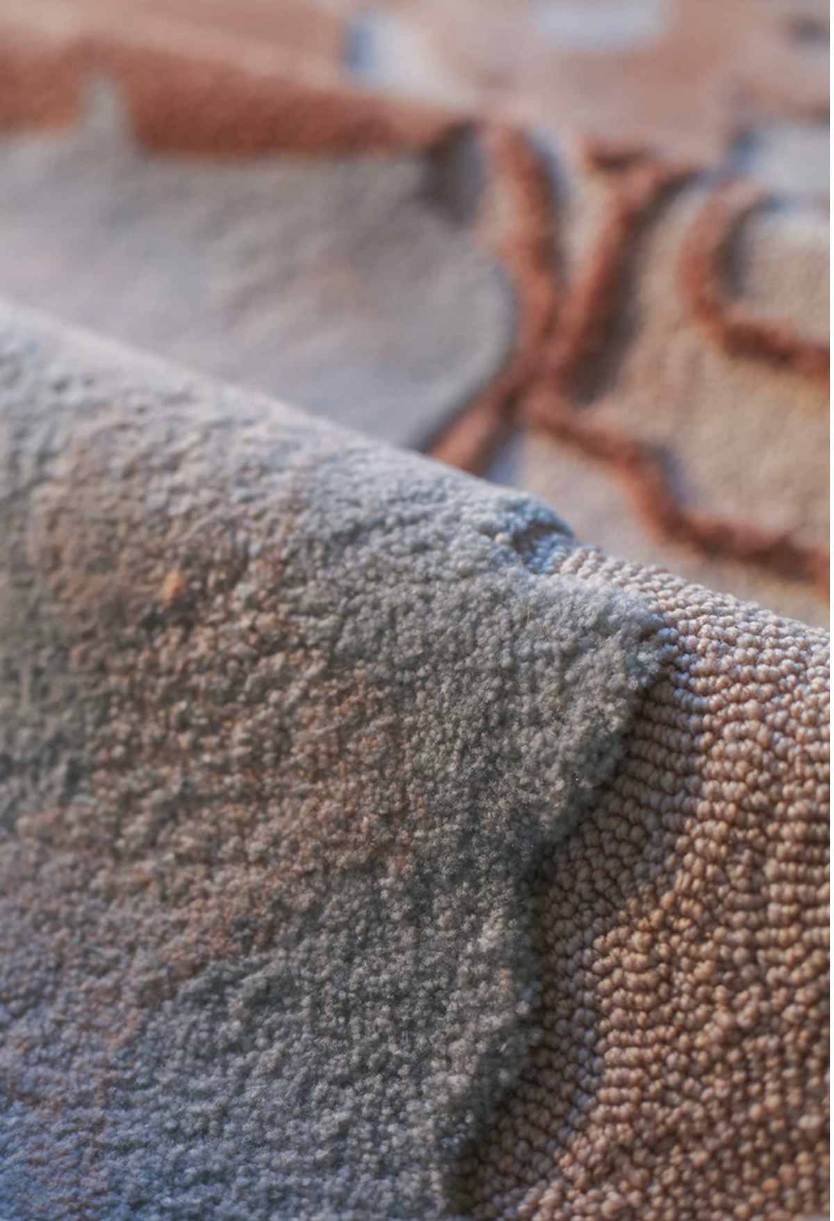 Hewn Earth Studio Delta rug in terracotta with intricate geometric patterns, displayed on a neutral background.
