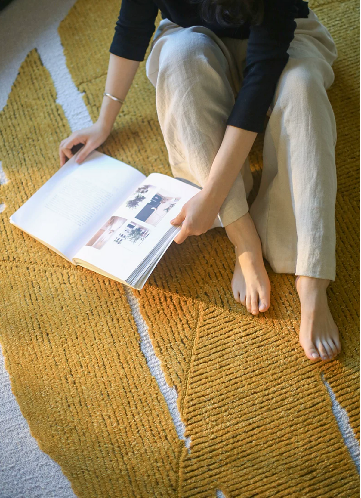 Gold leaf foil rug by Hewn Earth Studio featuring a shimmering metallic surface and textured design.
