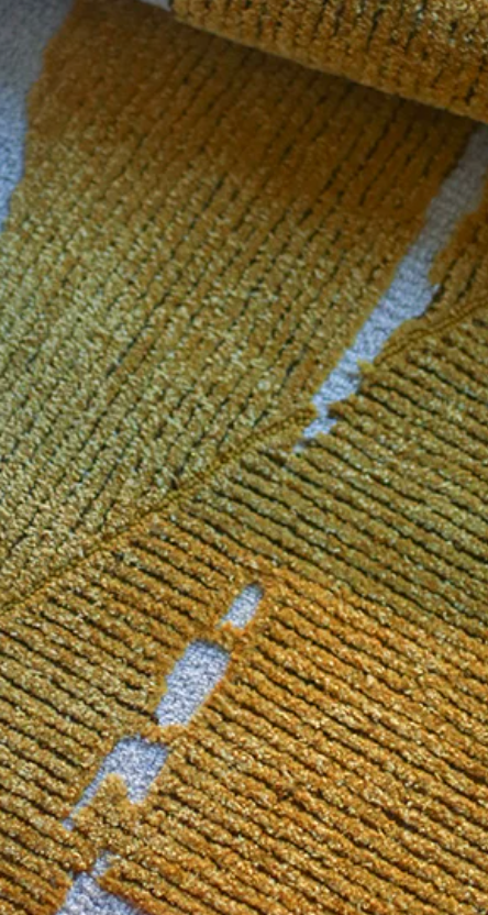Gold leaf foil rug by Hewn Earth Studio featuring a shiny, metallic surface with intricate leaf patterns.