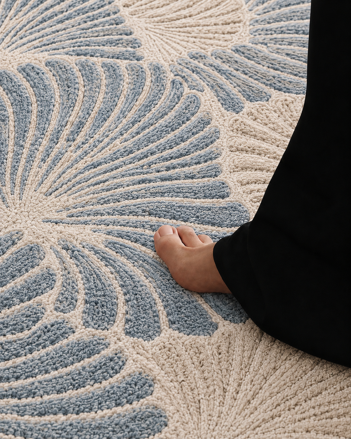 Hewn Earth Studio Frond rug with slate-colored woven design and textured edge, showcasing a modern, artisanal home decor piece.
