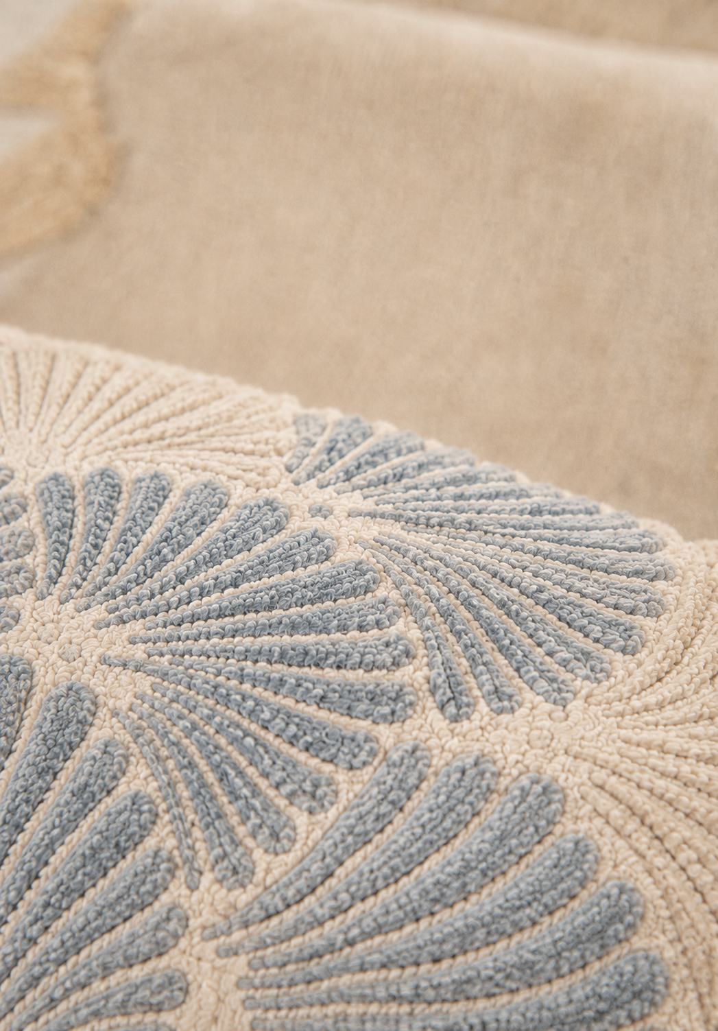 Hewn Earth Studio Frond slate rug with textured, natural design, shown on floor with foot for size comparison.