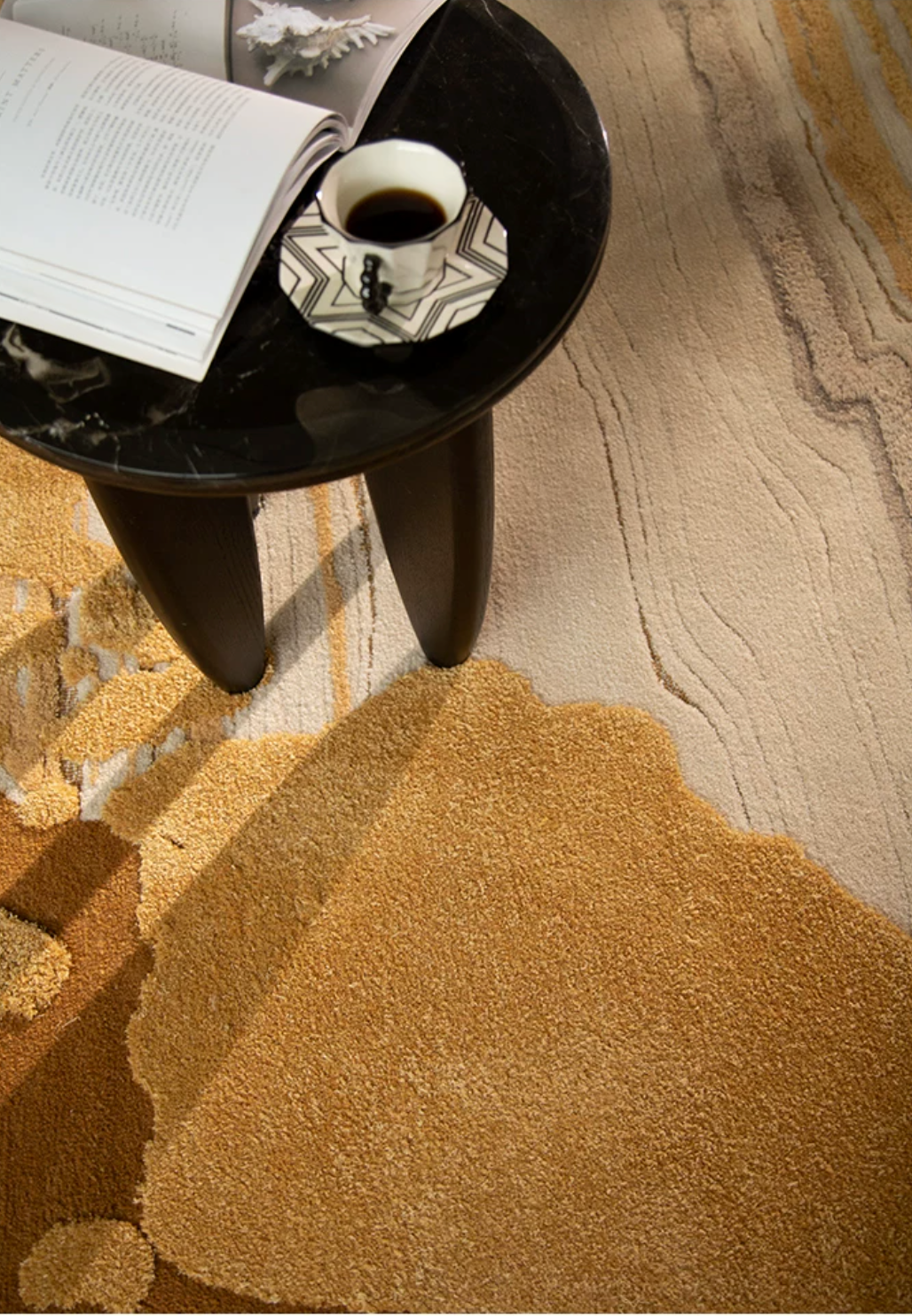 Hewn Earth Studio Lode rug in Gilt color with textured woven pattern, displayed on a wooden floor.