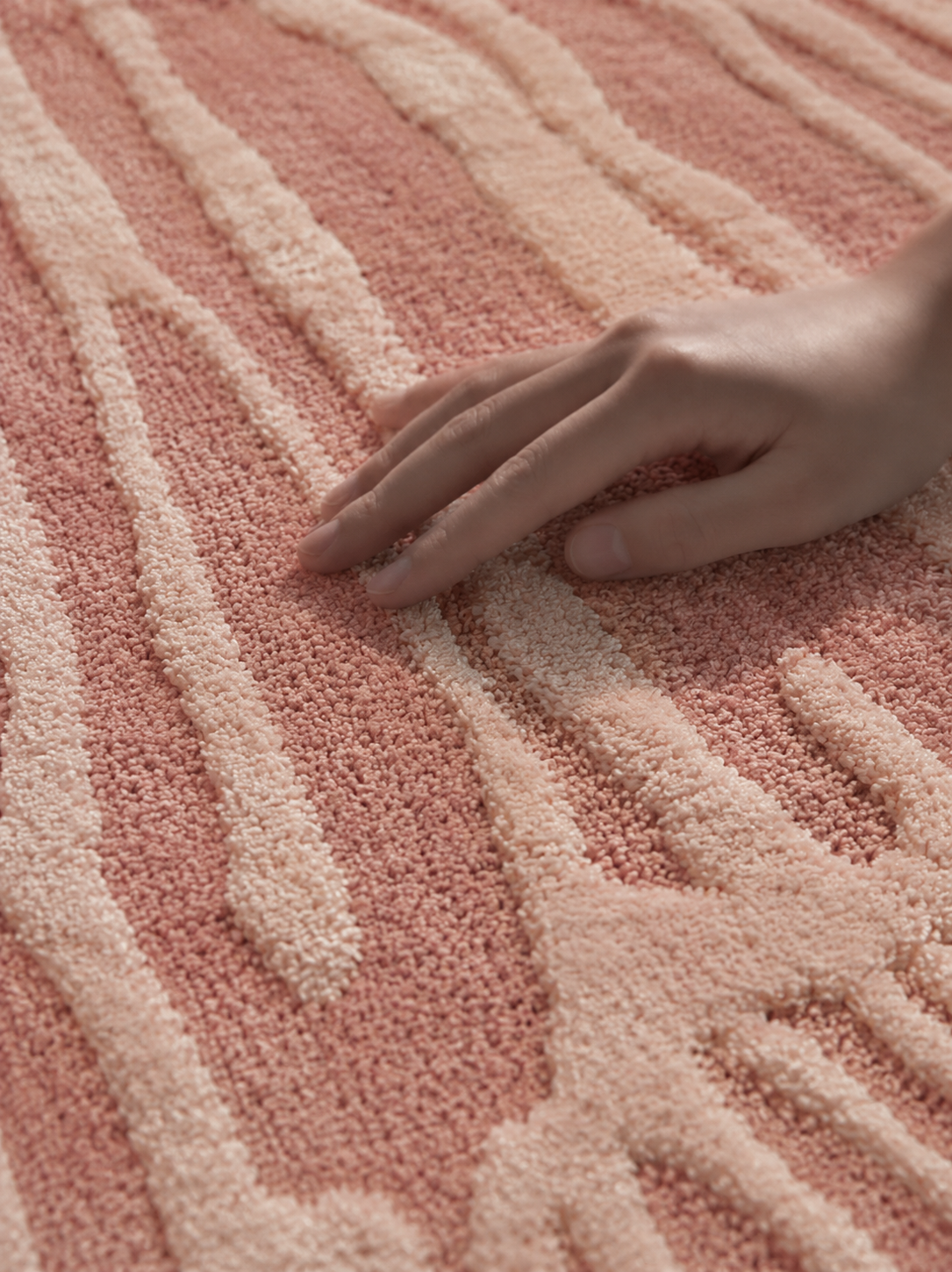 Hewn Earth Studio Lotus blush pink rug with intricate pattern, shown on a table, showcasing soft, textured fabric and elegant design.