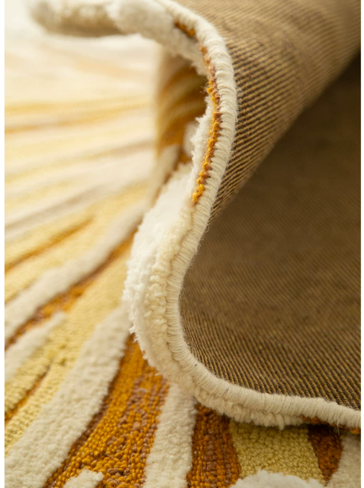 Hewn Earth Studio Solene rug in marigold and amber floral design with decorative edge detail.