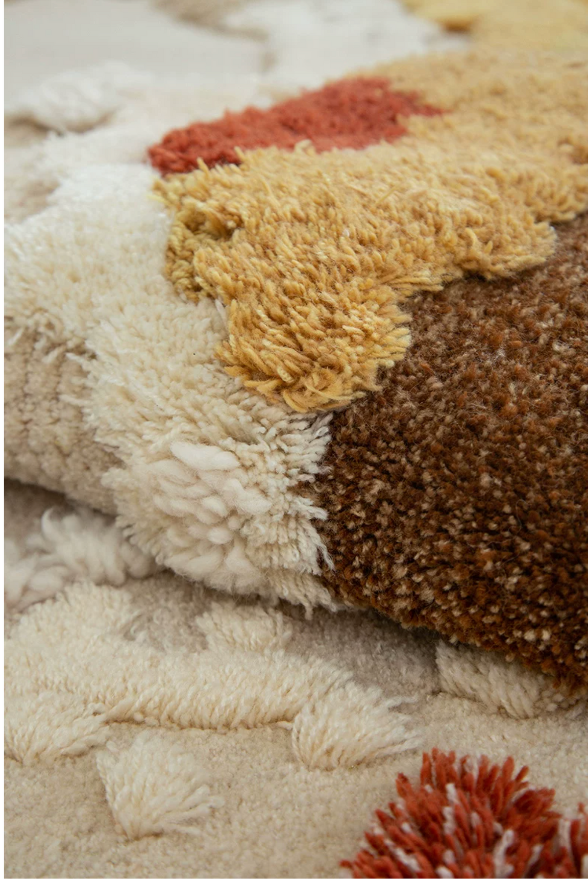 Hewn Earth Studio Meadow rug showing autumn-themed folded design with earthy tones and intricate patterns.