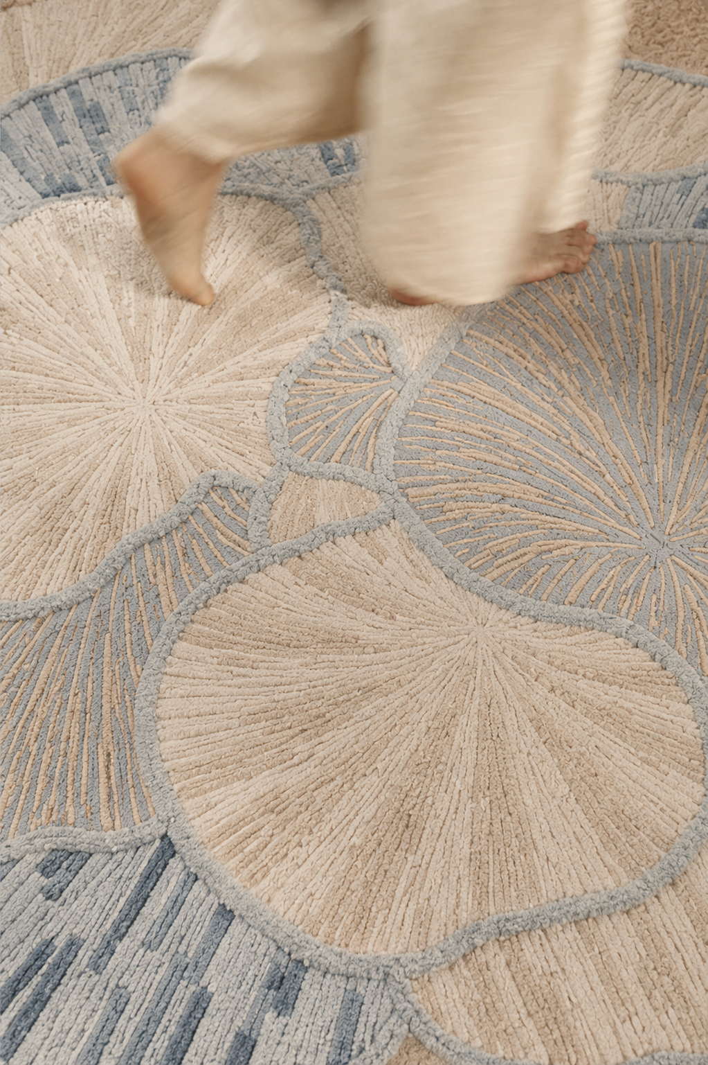 Hewn Earth Studio Petal rug featuring mist and cream colors with a soft, textured design on a wooden floor.
