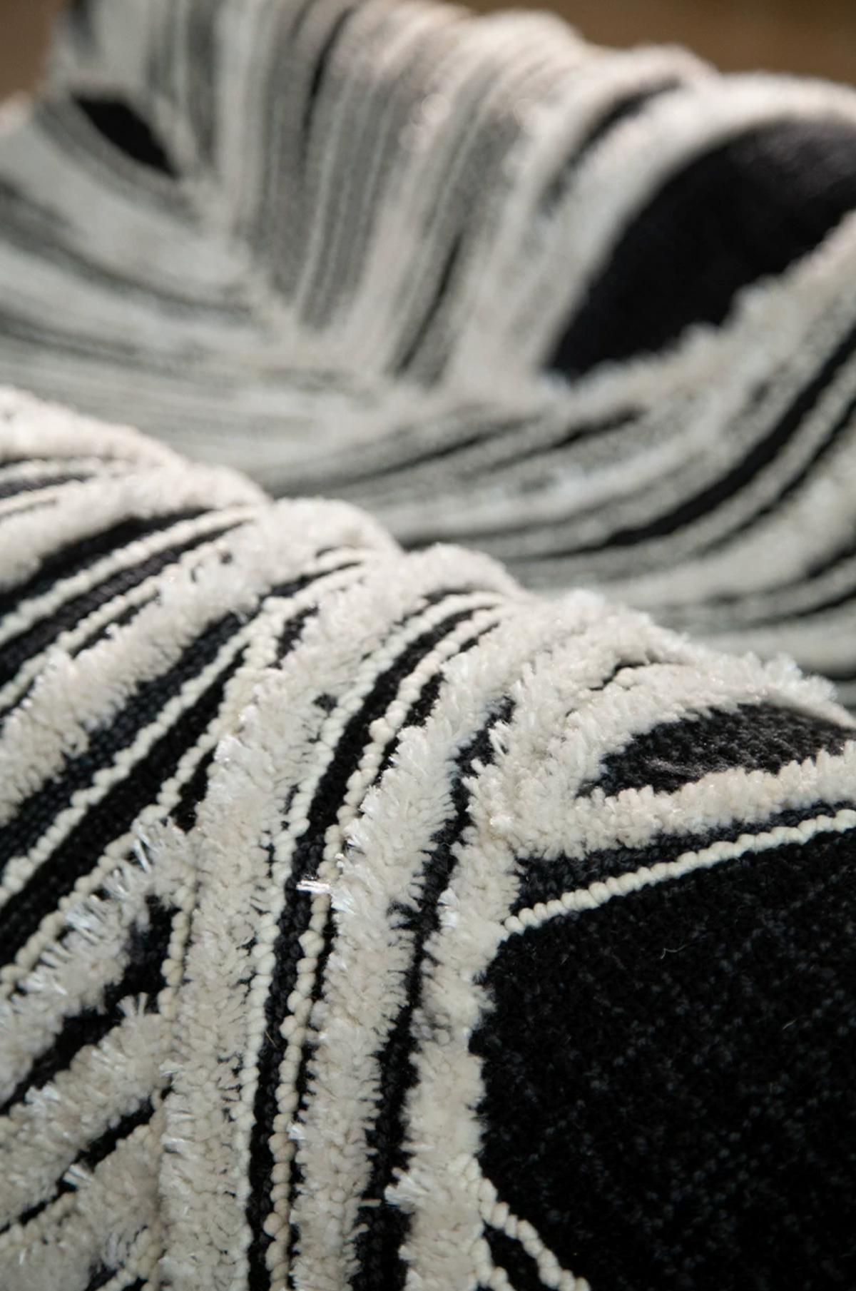 Hewn Earth Studio Plume rug featuring intricate ink and bone-colored patterns, showcasing detailed textile design.