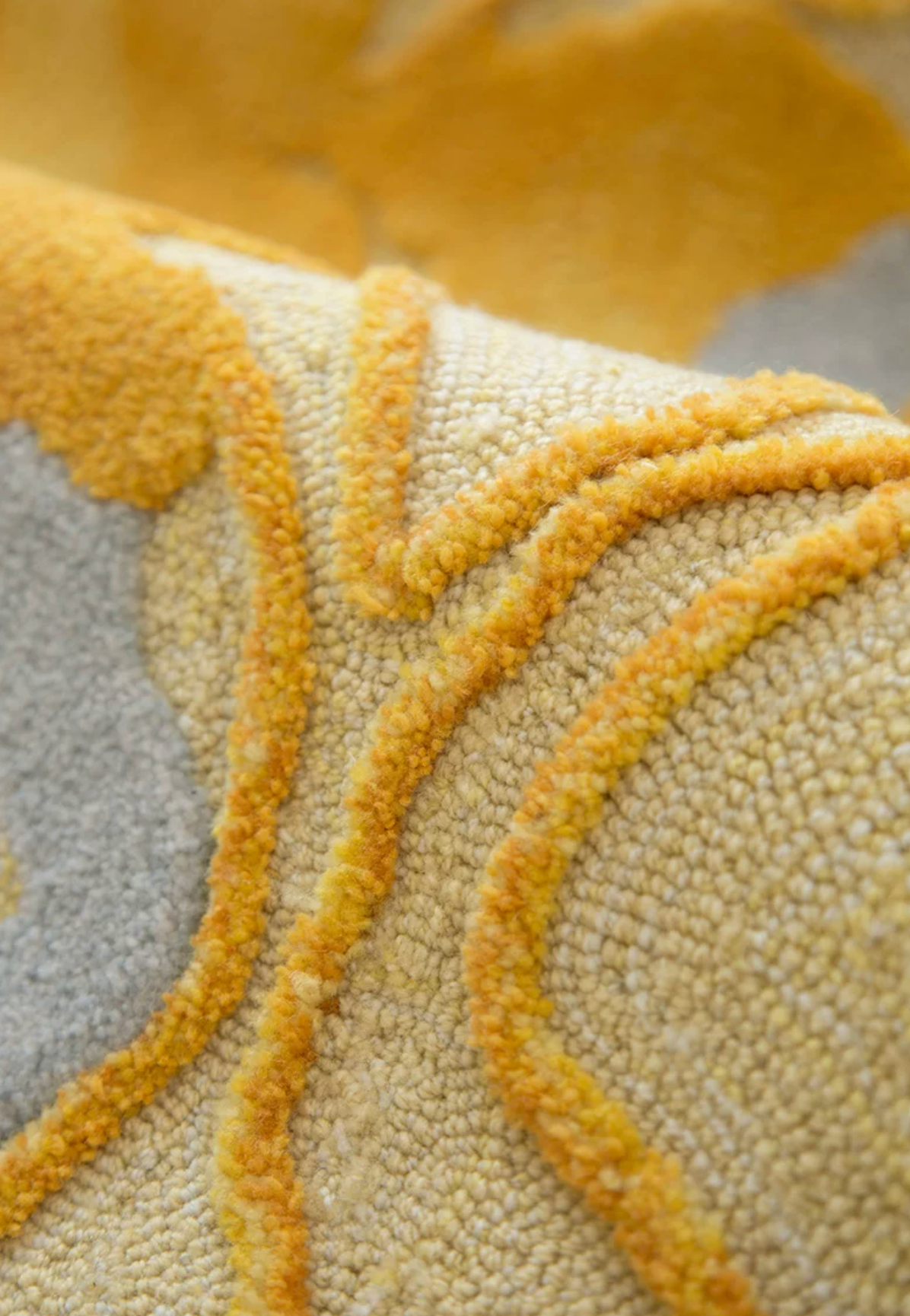 Close-up of Hewn Earth Studio's Strata rug in Saffron, showcasing detailed woven pattern and vibrant orange color.