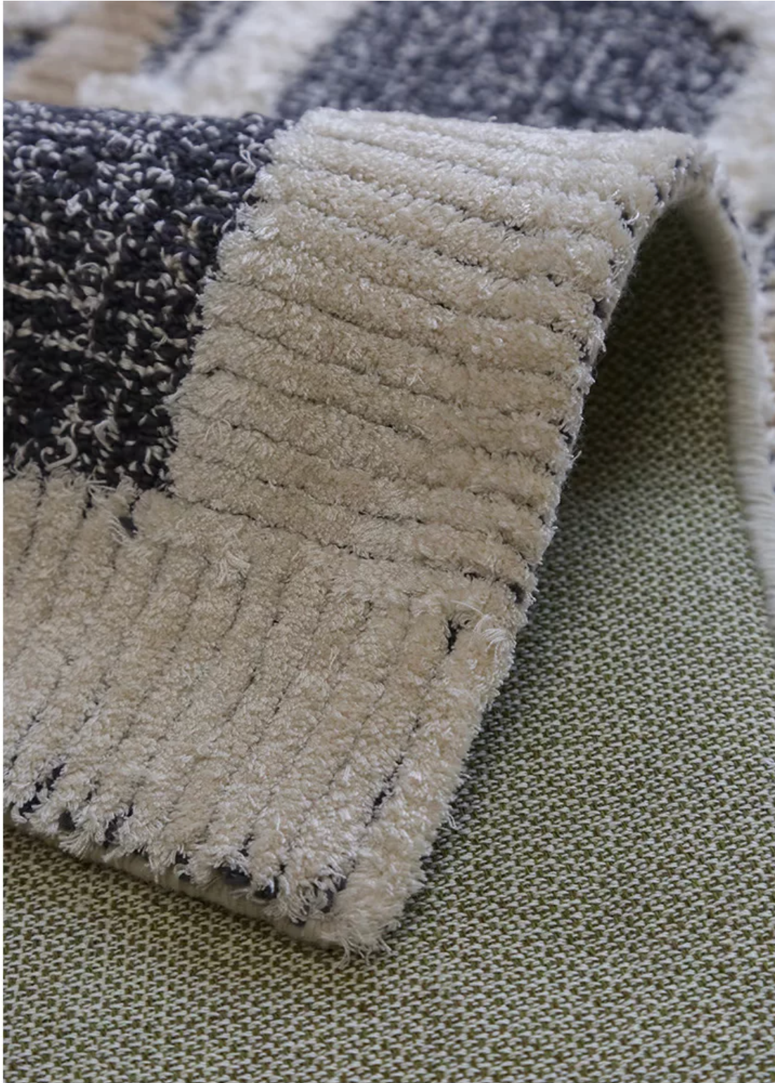 Hewn Earth Studio tartan charcoal rug grid pattern, soft woven textile with geometric design, view of the back side.