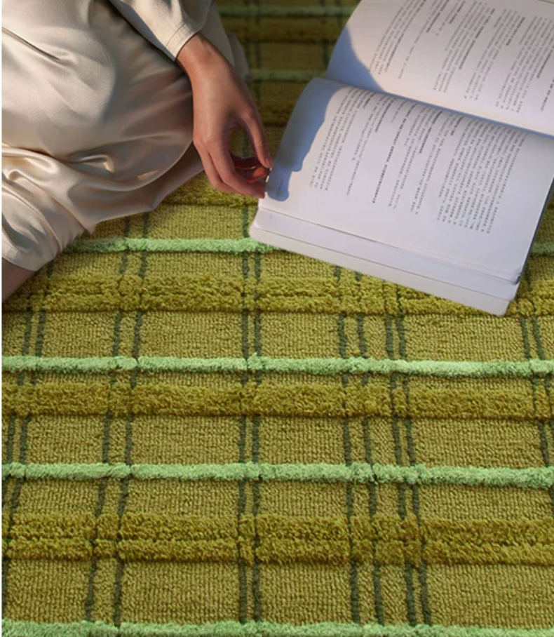 Hewn Earth Studio tartan moss rug grid pattern, soft woven textile with green and earthy tones on a textured surface.