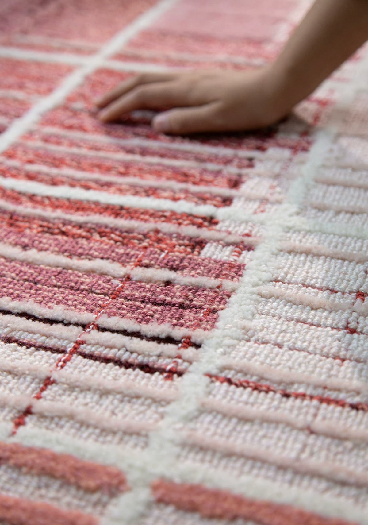 Hewn Earth Studio Weft rug in rose color, textured woven design, displayed in a cozy interior setting.