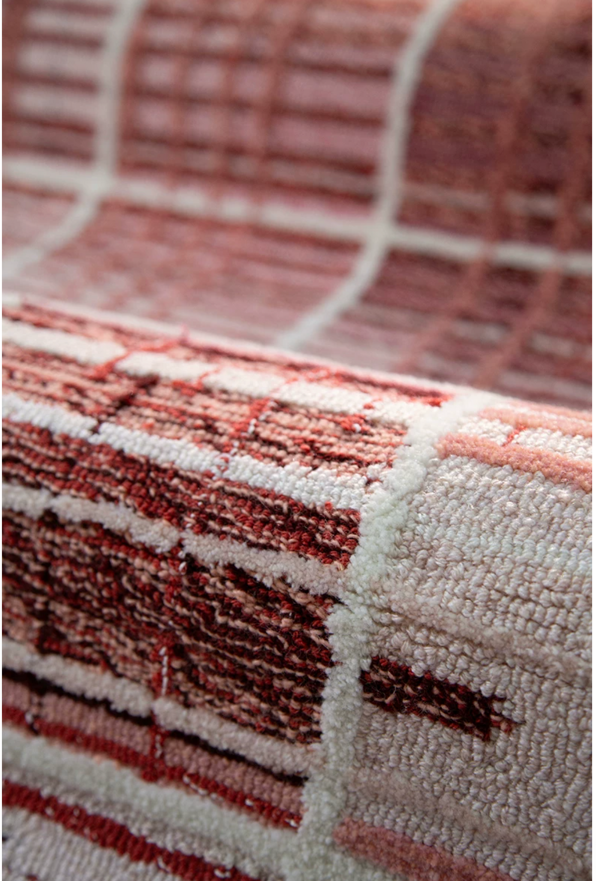 Hewn Earth Studio Weft rug in rose color with woven textile pattern, displayed in a cozy interior scene.