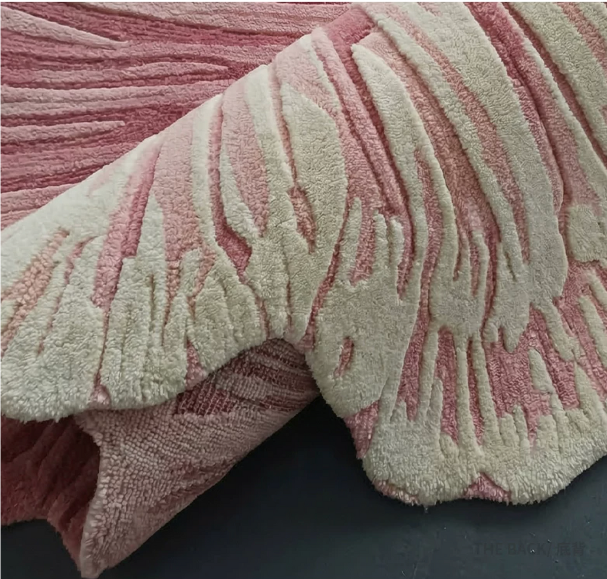 Hewn Earth Studio Solene rug featuring an anemone-inspired pattern in soft, natural tones on a textured fabric background.
