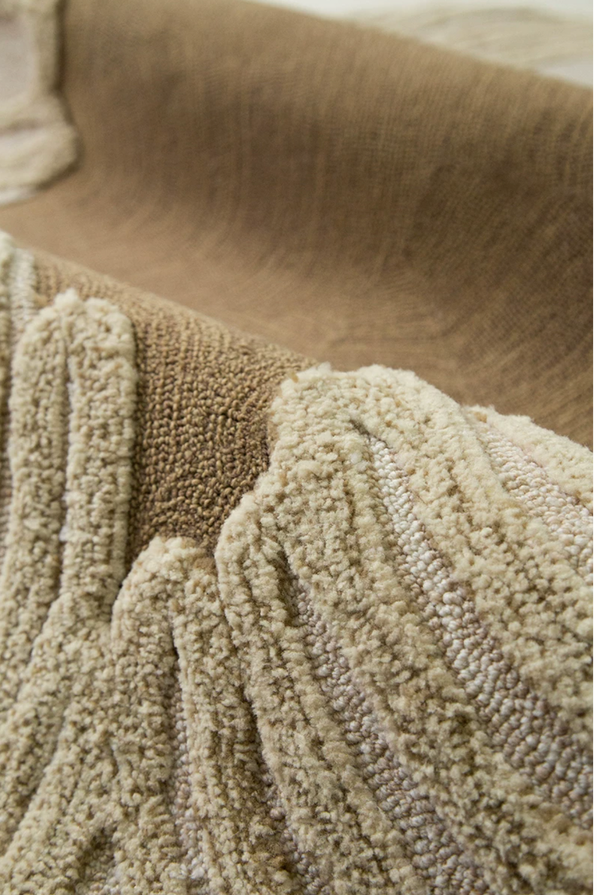 Hewn Earth Studio Camellia rug with a clay-colored side showing intricate woven pattern and textured surface.
