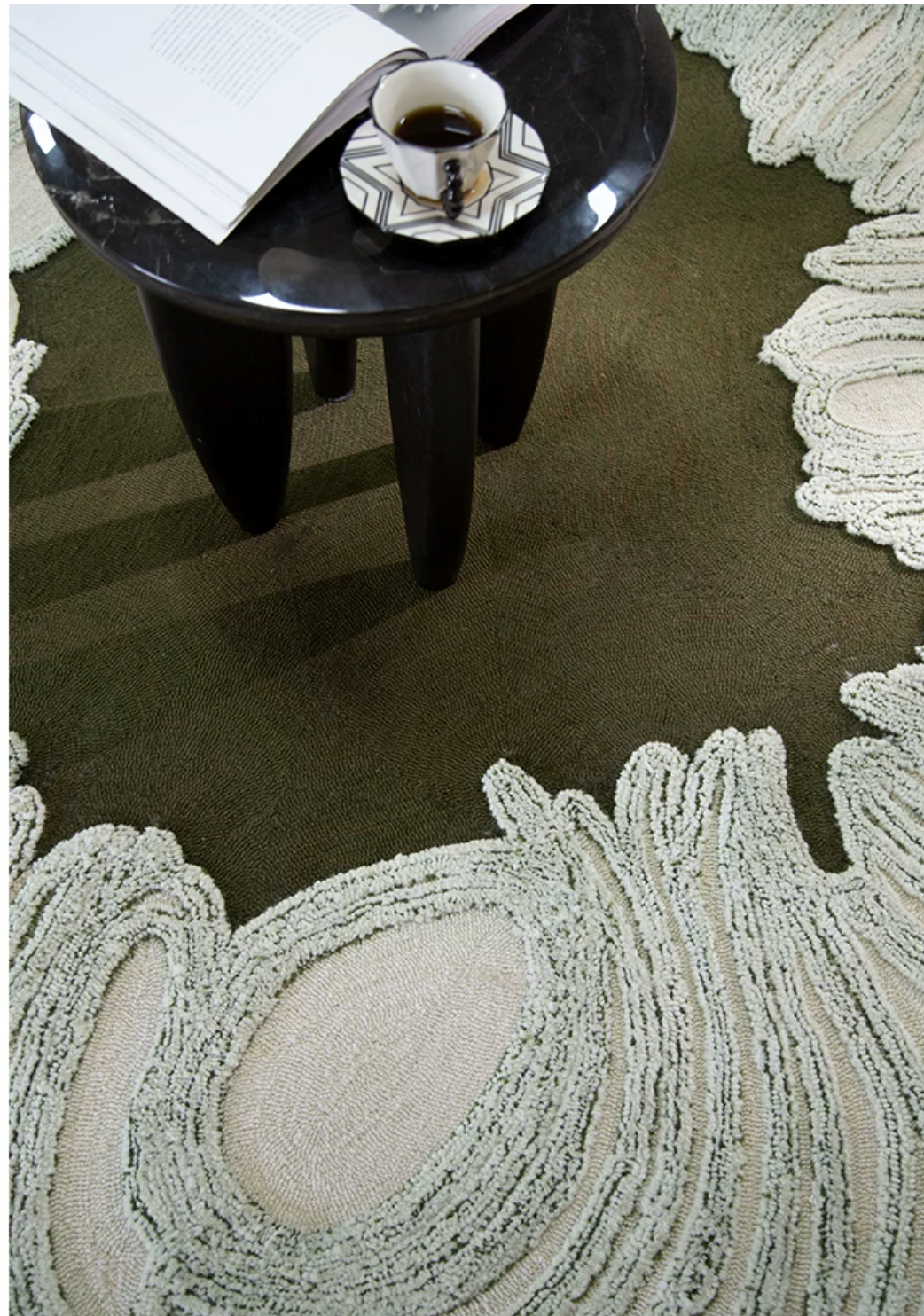 Hewn Earth Studio Camellia rug with moss green and beige tones, showcasing a soft, textured woven design on a neutral background.