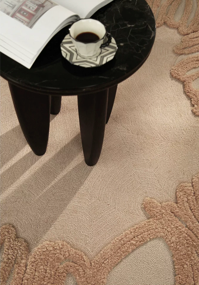 Hewn Earth Studio Camellia rug with intricate floral patterns, shown from a side angle, in soft earthy tones.