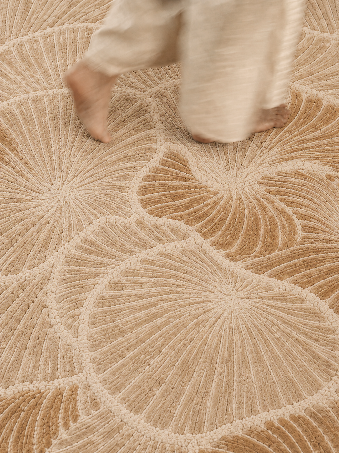 Hewn Earth Studio Frond rug with a sand-colored edge, featuring a woven textured design in natural earthy tones.