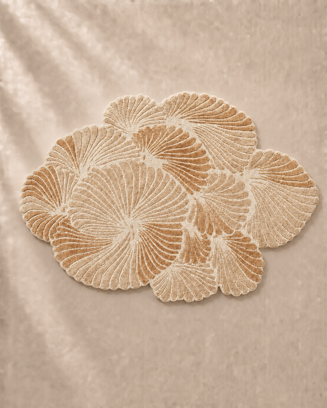 Hewn Earth Studio Frond rug with intricate leaf pattern in sand color, showcasing textured woven design on a neutral background.