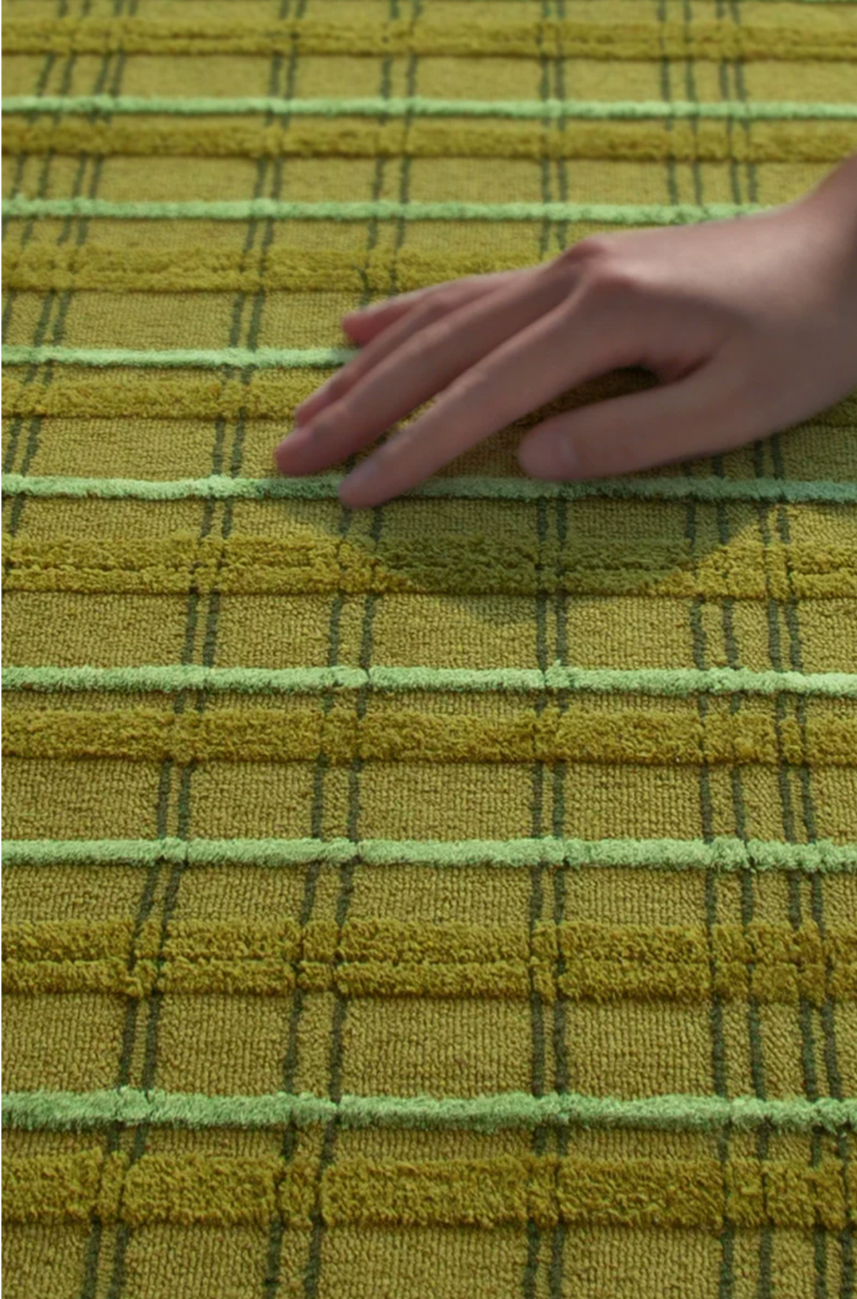 Hewn Earth Studio moss grid rug with a textured, natural moss pattern showcasing a close-up macro view of the rug's surface.