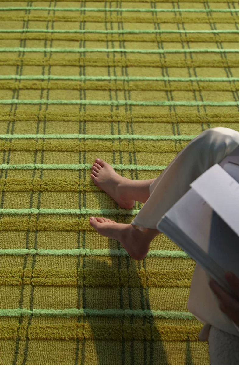 Hewn Earth Studio moss green grid rug with geometric pattern, soft textured surface, ideal for modern living room or bedroom decor.