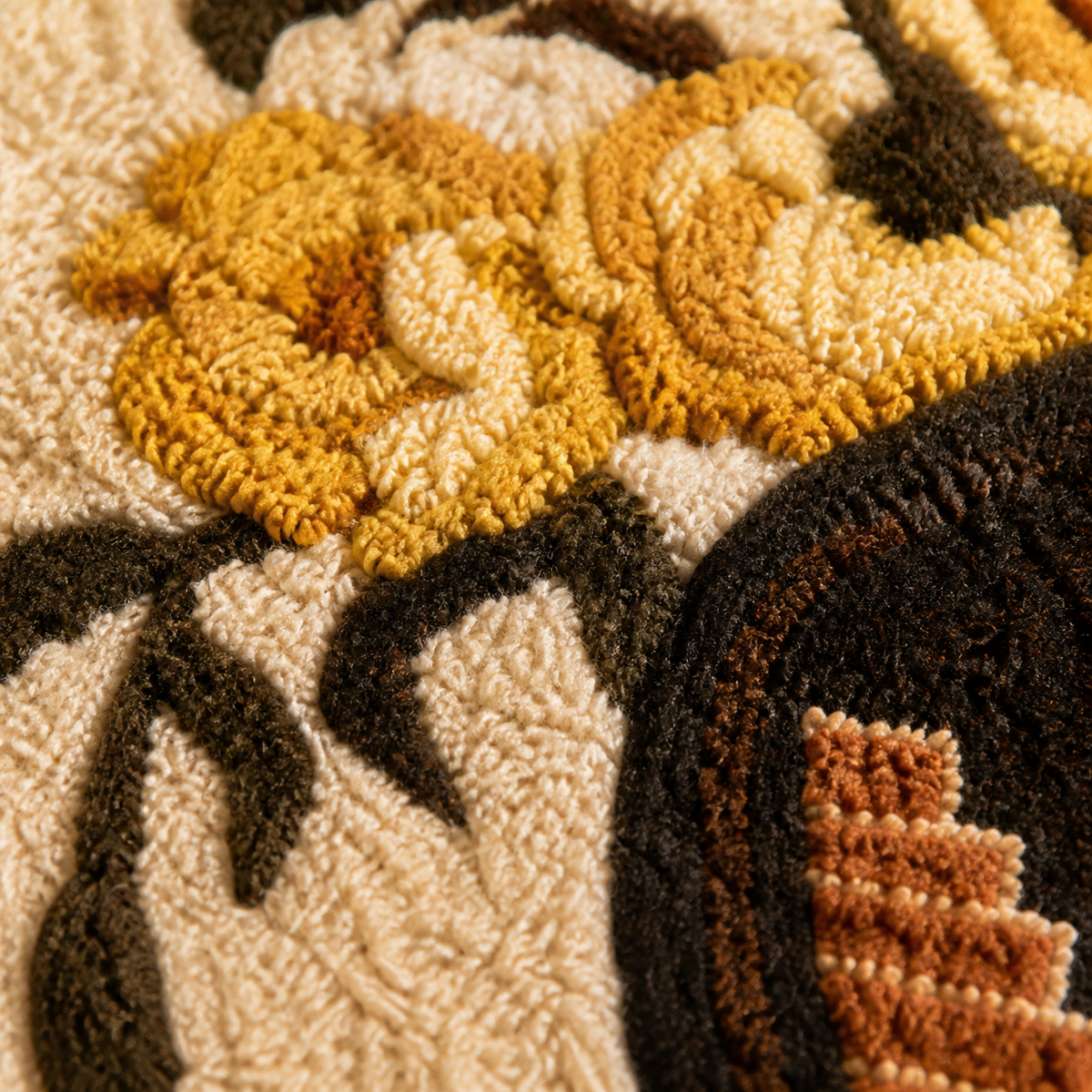 Close-up of Hewn Earth Golden Rose wall art urn with detailed golden rose design on textured background.