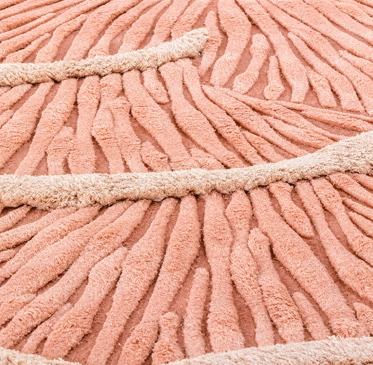 Hewn Earth Studio Palma rug featuring a detailed close-up of textured woven fabric with feet resting on it.