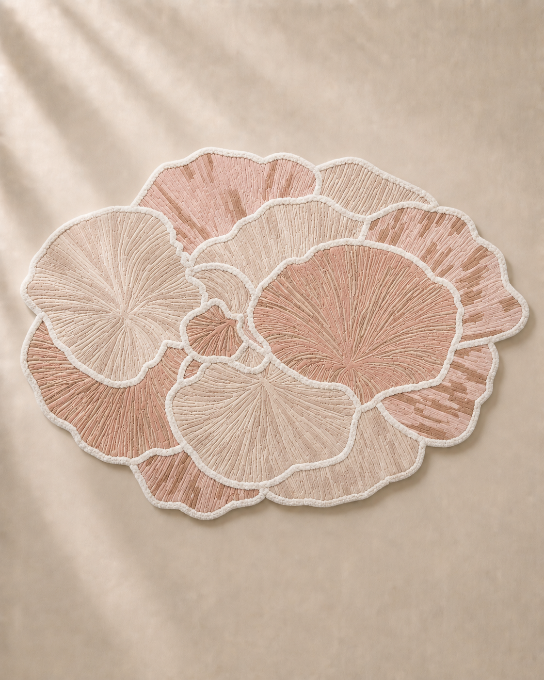Hewn Earth Studio Petal blush rug with floral petal design on soft, textured fabric for cozy home decor.
