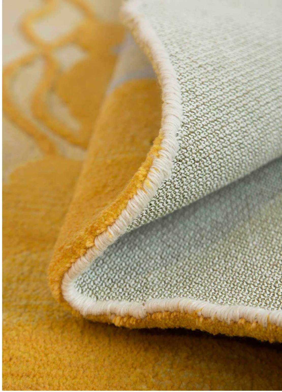 Hewn Earth Studio Strata saffron rug with intricate geometric patterns, displayed on a neutral background.