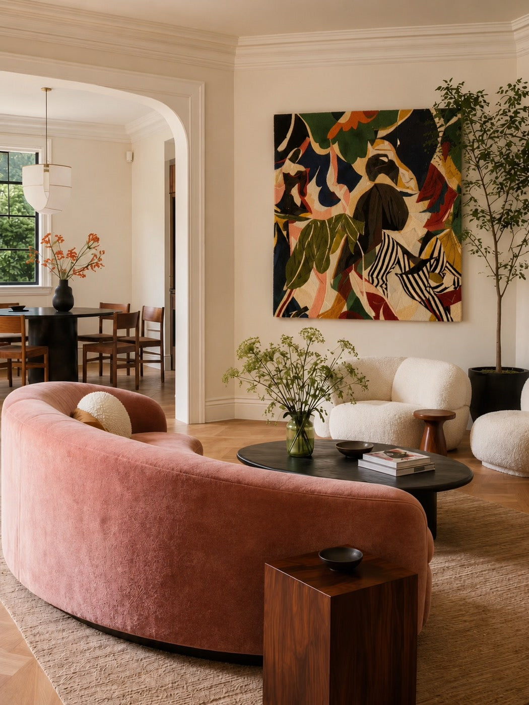 A hand-tufted wool jungle-foliage panel in olive, navy and rust hung above a curved rose velvet sofa