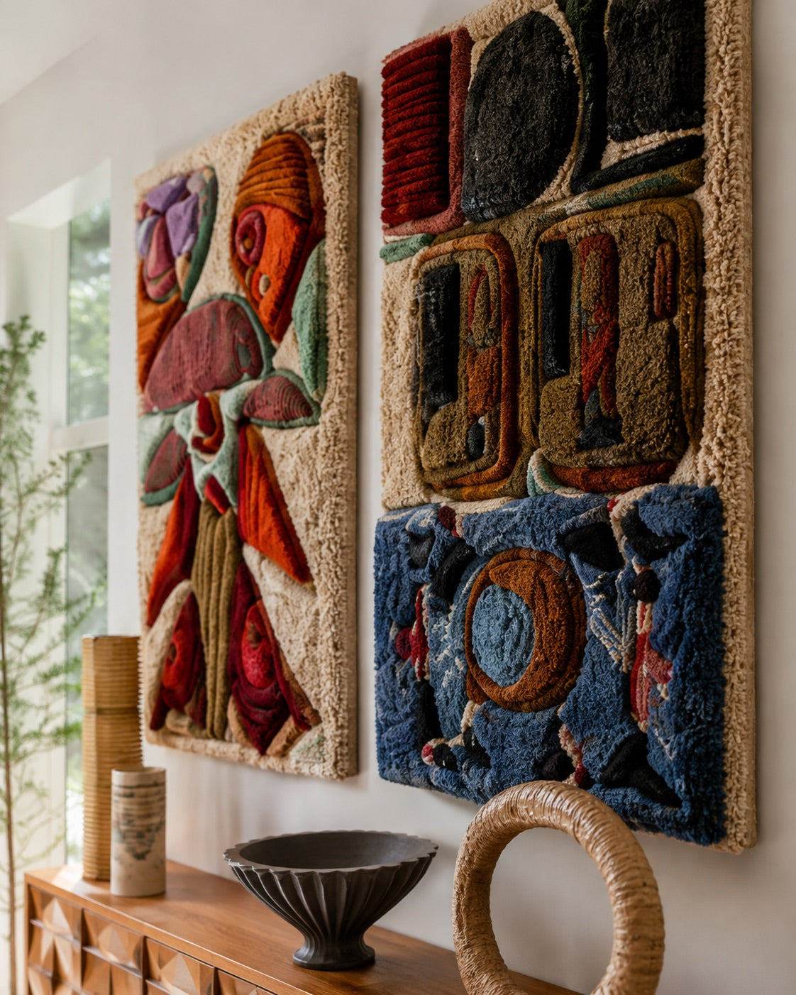 Close-up angle of two hand-tufted wool wall panels — a floral botanical motif and a geometric abstract motif