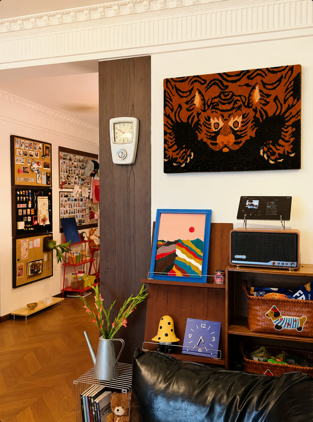 A hand-tufted wool tiger portrait in rust and black hung above a record player in a collector's apartment